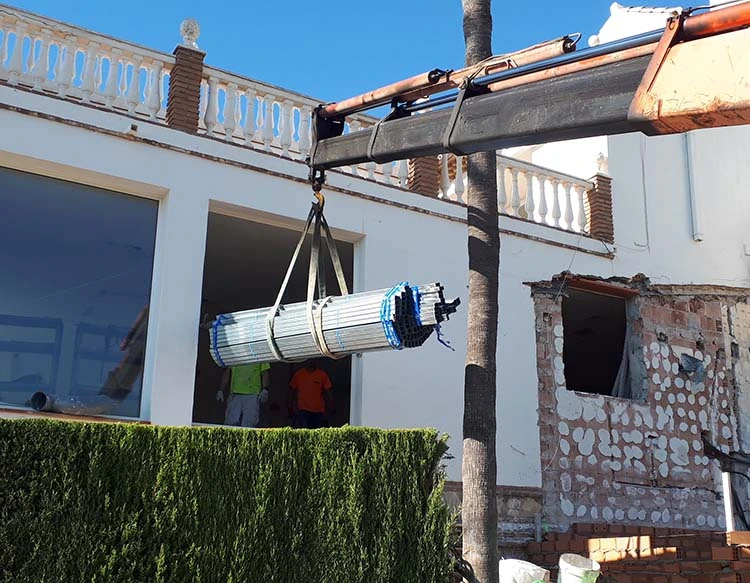 Camión pluma trabajando en Nerja con carga elevada de hierros