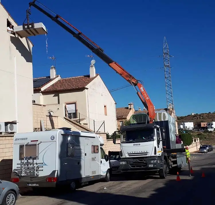 Camión pluma haciendo un servicio de elevacion de carga