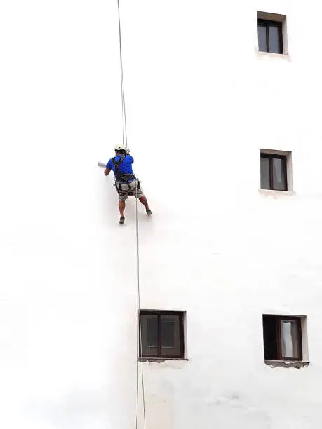 Pintando la fachada de un edificio sin andamios con cuerdas Profesionales Málaga