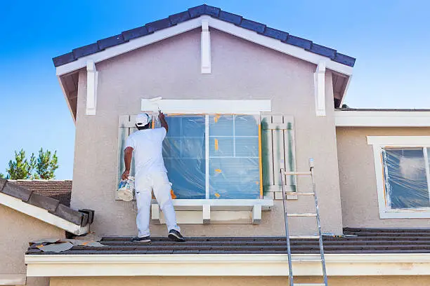 Un pintor pintando la fachada de un chalet en Málaga Profesionales Málaga