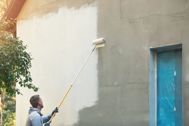 Pintor pintando la fachada de una casa de campo en Málaga - Profesionales Málaga